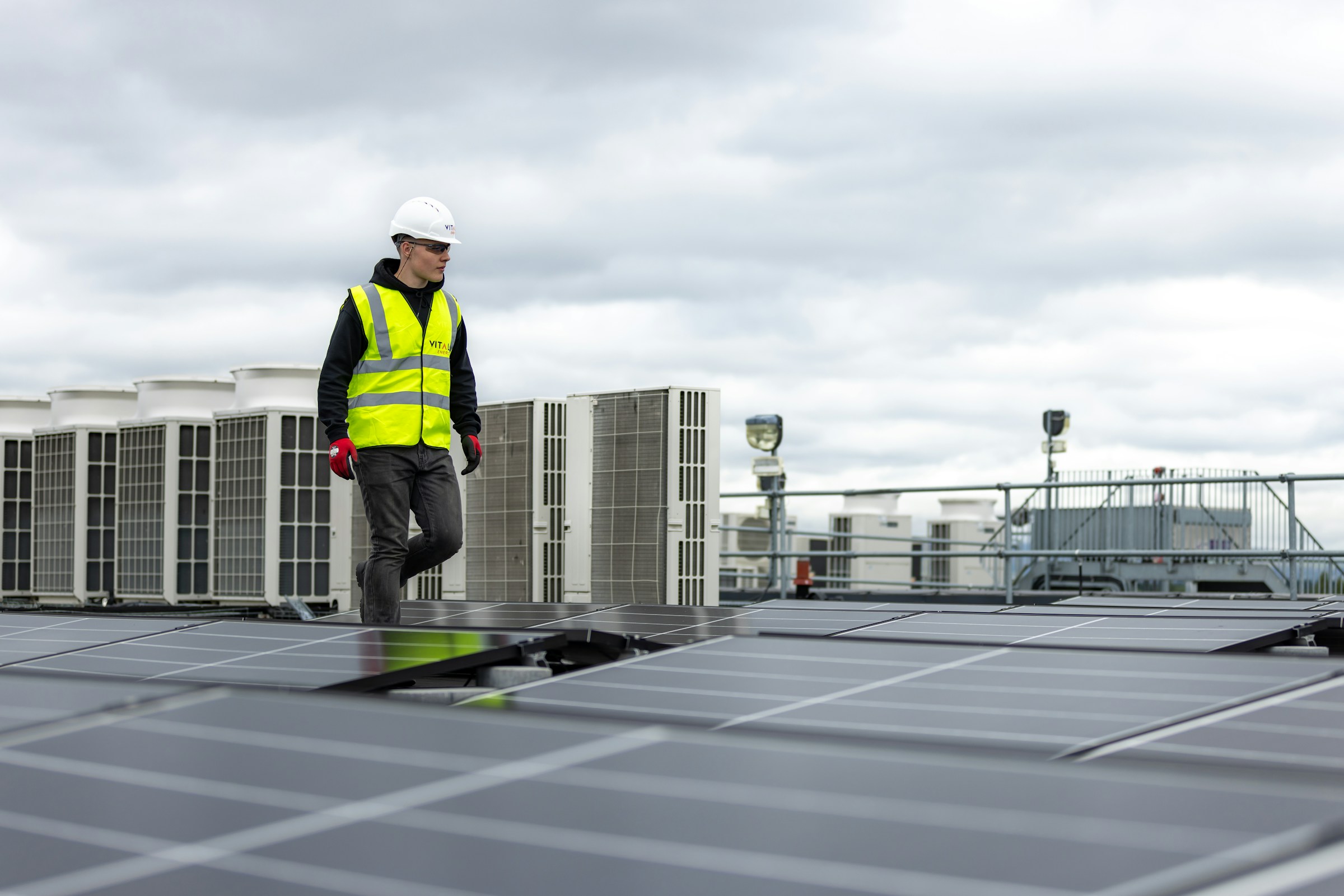 Hermes HVAC technician inspecting rooftop condenser units