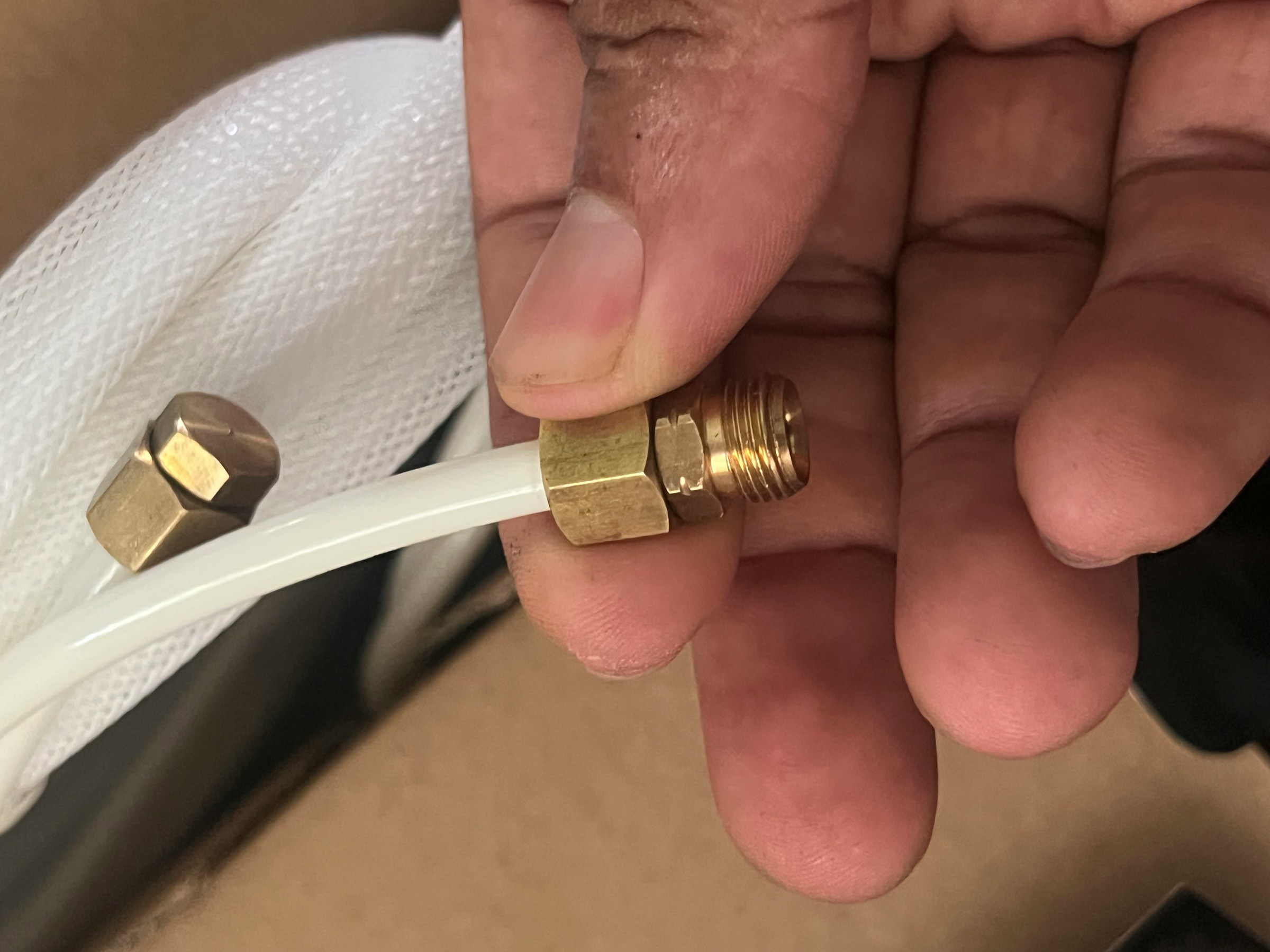 Technician connecting a refrigerant line fitting during a repair call